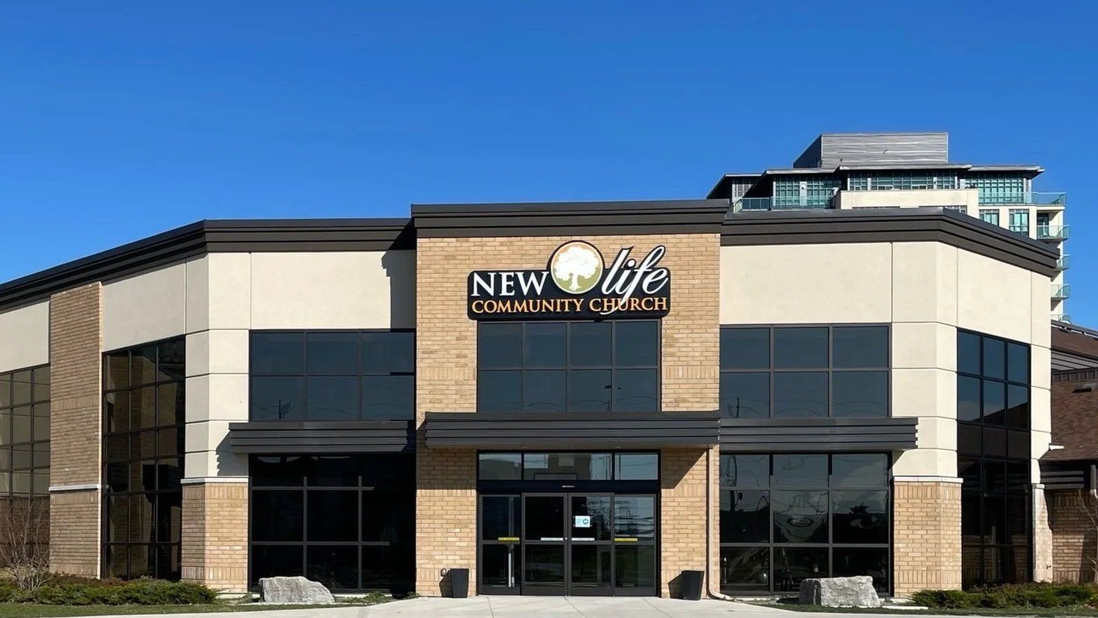 New Life Community Church, a modern tan-brick building with a glass entrance beneath its sign