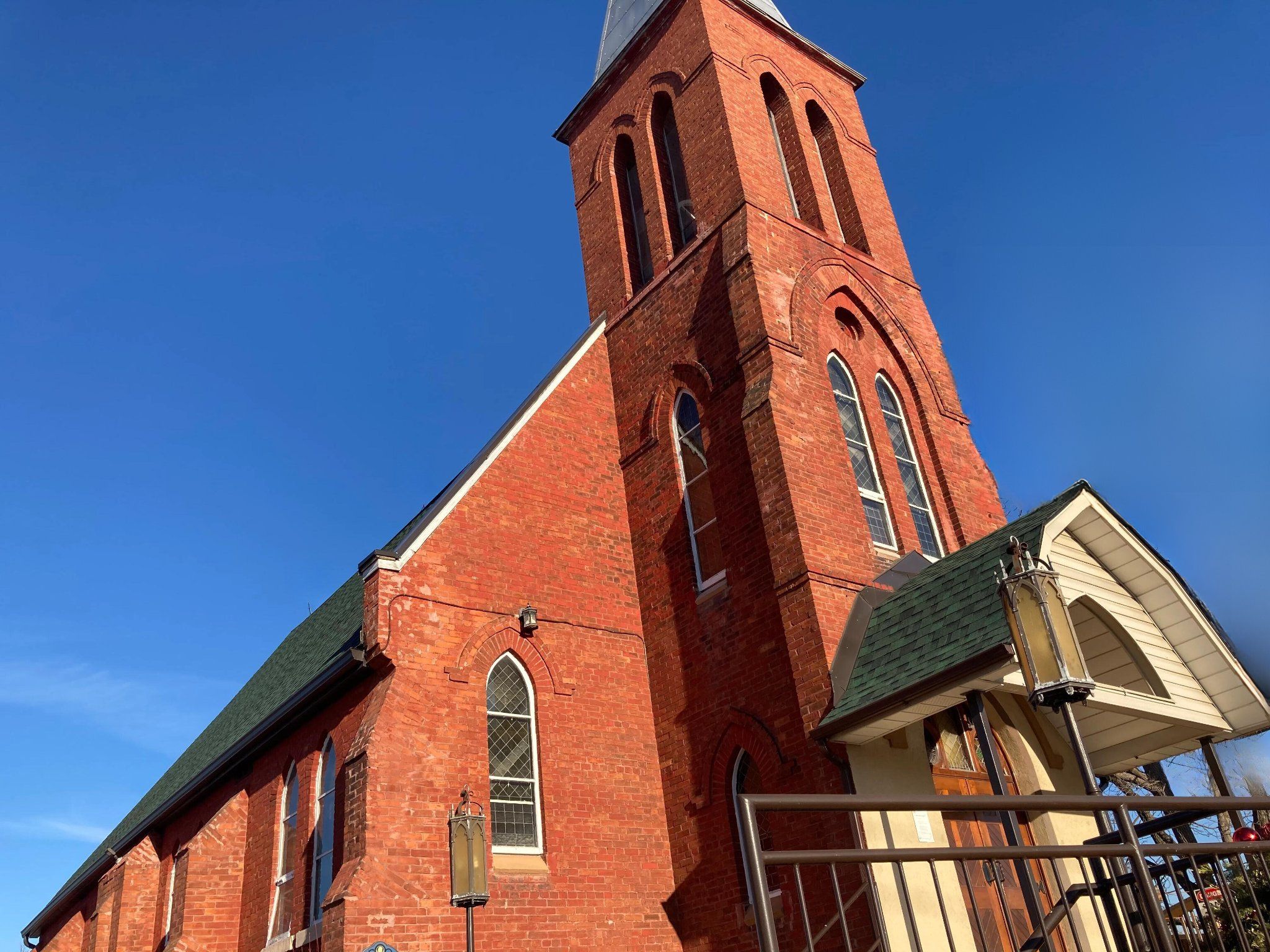 The red-brick tower and gable of St. Patrick's Church at Wildfield against a deep blue sky